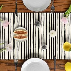 Flat lay of striped table runner on a wooden surface with tulips and elegant tableware