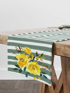 Detail of floral table runner with green stripes and yellow flowers on wooden table