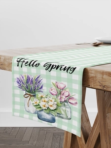 Detail of floral table runner with Hello Spring text on a light wood dining table