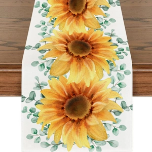 Spring sunflower and eucalyptus leaves table runner on dark wood dining table background