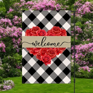 Dettaglio della bandiera da giardino a scacchi con cuore di rose e scritta welcome su asta