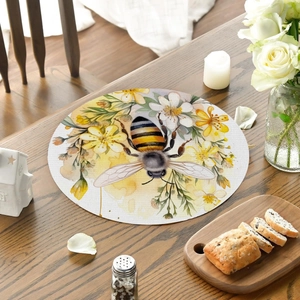 Detail of round linen placemat with watercolor bee and wild floral pattern on dark wood