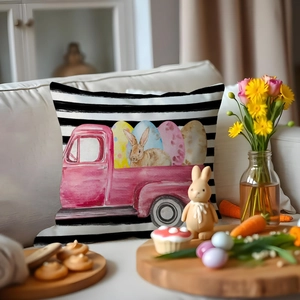 Housse de coussin Pâques avec camion rose aquarelle et motif lapin sur canapé blanc