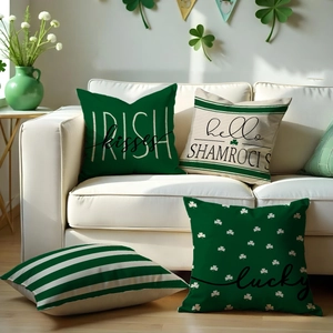 Set of four St. Patrick's Day pillow covers with clover patterns on a cozy white sofa