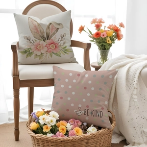 Detail of Easter pillow covers featuring bunny floral prints and Be Kind text on a chair