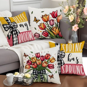 Detailed close-up of four spring tulip pillow covers with floral patterns on a gray sofa