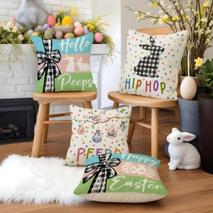 Set of four Easter pillow covers with bunny and egg designs on a wooden chair