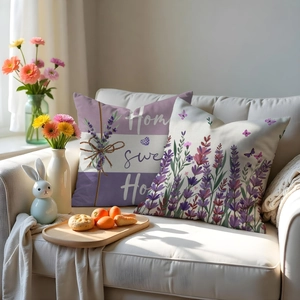 Detailansicht der Lavendel-Kissenbezüge aus Leinen mit Home Sweet Home-Druck auf dem Sofa