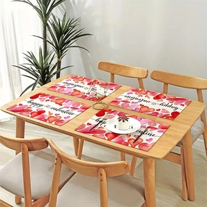 Close-up of white rectangular Valentine's Day placemats with watercolor hearts on wood table