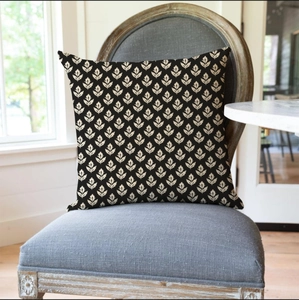 Detail of floral black and beige square throw pillow on a modern grey fabric chair