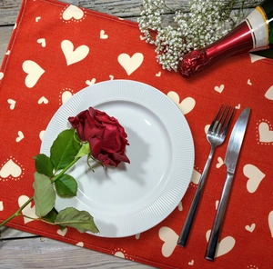 Close-up of red festive placemat with white heart patterns for romantic table decor