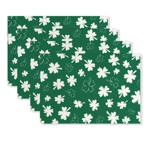 Set of four St. Patrick's Day placemats with white shamrock pattern on dark green fabric
