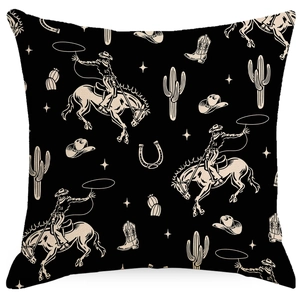Detail of vintage cowboy pattern cushion cover with horses and cactus on black fabric