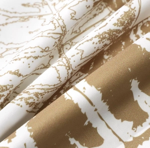 Close-up of peach skin fabric with plant leaf patterns and soft texture detail
