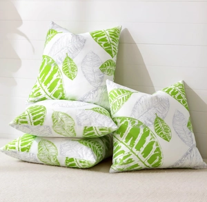 Detailed close-up of botanical leaf print patterns on white square throw pillow covers