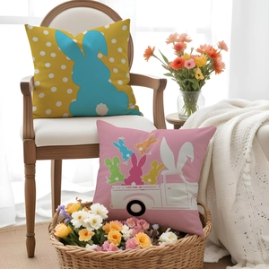 Close-up of Easter linen cushion covers with rabbit silhouette and colorful truck patterns
