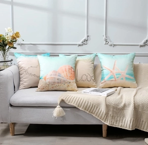 Close-up of waterproof linen starfish cushion covers on a grey sofa with coastal decor