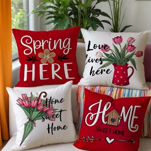 Set of four floral spring decorative pillow covers in red and beige on a cozy sofa
