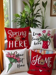 Detailed close-up of floral and letter print pillow covers on a white sofa in a cozy room