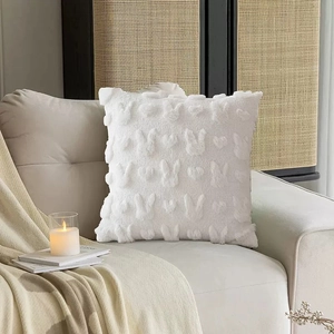 White plush Easter pillow cover with rabbit embroidery and hearts on a white sofa