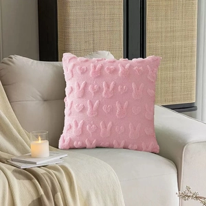 Close-up of 3D embossed rabbit and heart patterns on pink plush velvet pillow cover