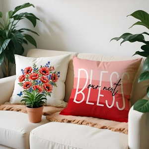 Detail of Nordic decorative pillows with red poppy prints and BLESS slogan on white sofa