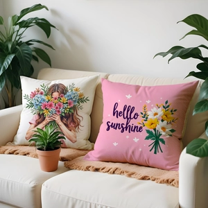 Detailed view of pink floral and sunshine illustration linen cushion covers on a sofa