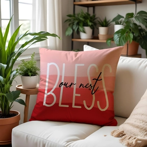 Close-up of red gradient pillow cover with BLESS our nest text on white sofa