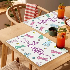 Détail de sets de table de Pâques avec des lapins colorés et texte Happy Easter sur bois