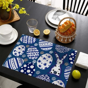 Détail du set de table de Pâques avec œufs bleus et lapin blanc sur table en bois foncé