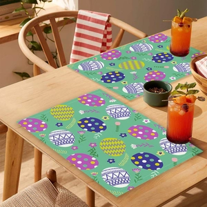 Détail de sets de table de Pâques avec motifs d'œufs et fleurs sur table en bois