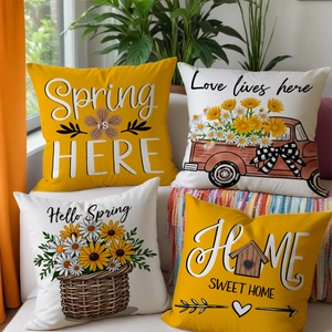Detail of four spring sunflower and daisy pillow covers on a white sofa in a living room
