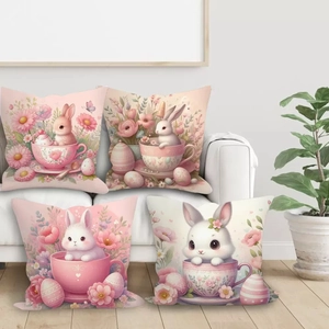 Set of four Easter pillow covers with cute rabbits and pink floral prints on a sofa