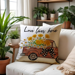 Detail of sunflower and red truck pillow cover with Love lives here text on a sofa