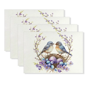 Detail of four Easter linen placemats showing watercolor birds, eggs and floral patterns