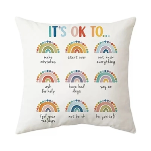 Close-up detail of white throw pillow cover with rainbow patterns and motivational quotes