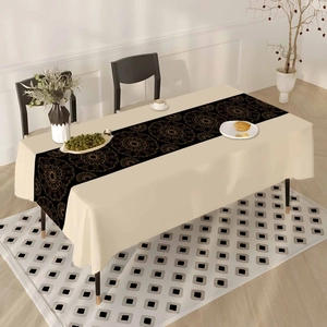 Detail of bohemian black and gold mandala table runner on cream tablecloth for dining decor