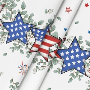 Detail der Stoffstruktur mit patriotischen Sternen und Eukalyptusblättern auf weißem Tuch