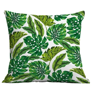 Close-up of tropical monstera leaf print on a square white decorative cushion cover