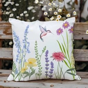Dettaglio della fodera per cuscino con colibrì e fiori su panca in legno in giardino