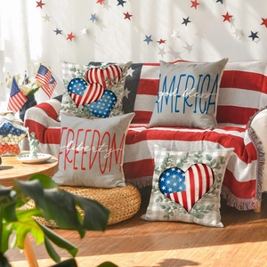 Detailed close-up of four patriotic July 4th pillow covers on a cozy living room sofa