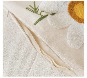Detailed close-up showing the invisible zipper and tufted floral texture on a canvas cushion cover