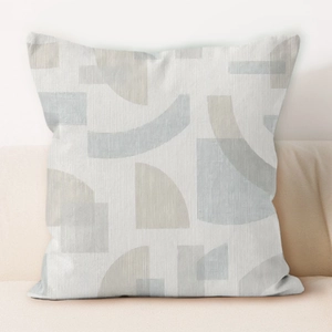 Close-up of cream geometric cushion cover with striped texture on a soft sofa