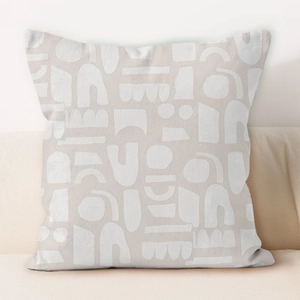 Modern cream geometric cushion cover with white abstract patterns on light grey fabric