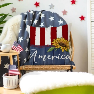 Detail of sunflower and America text on flag-themed cushion cover on a wicker chair