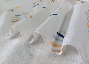 Close-up of microfiber beach towel showing soft texture and artistic line print patterns