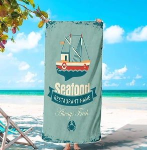 Microfiber beach towel with vintage seafood print design against a sunny ocean backdrop