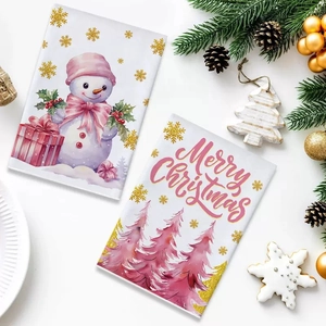 Detail of pink Christmas cards with snowman and tree motifs on a festive table setting