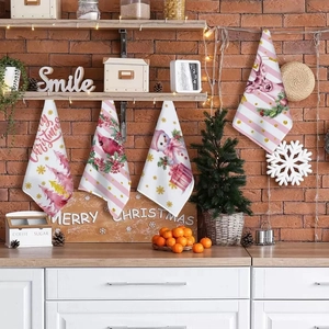 Close-up of four festive Christmas kitchen towels with snowman and red bird patterns