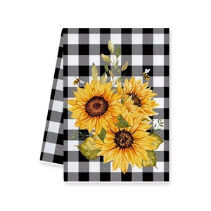 Detailed view of sunflower and honeybee print on black and white plaid linen tea towel